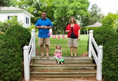 Amy with her family on top of an outdoor staircase holding a sign that says hope