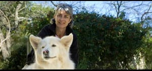 Deborah C. with white dog and the words Deborah's Recurrence Score result indicated that her risk of recurrence was low.