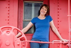 Deborah W. standing in front of a red structure